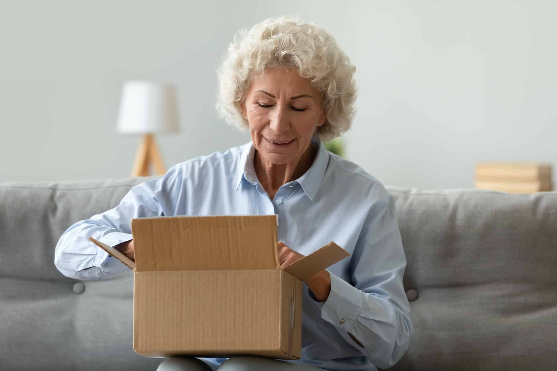 Happy elderly woman open parcel